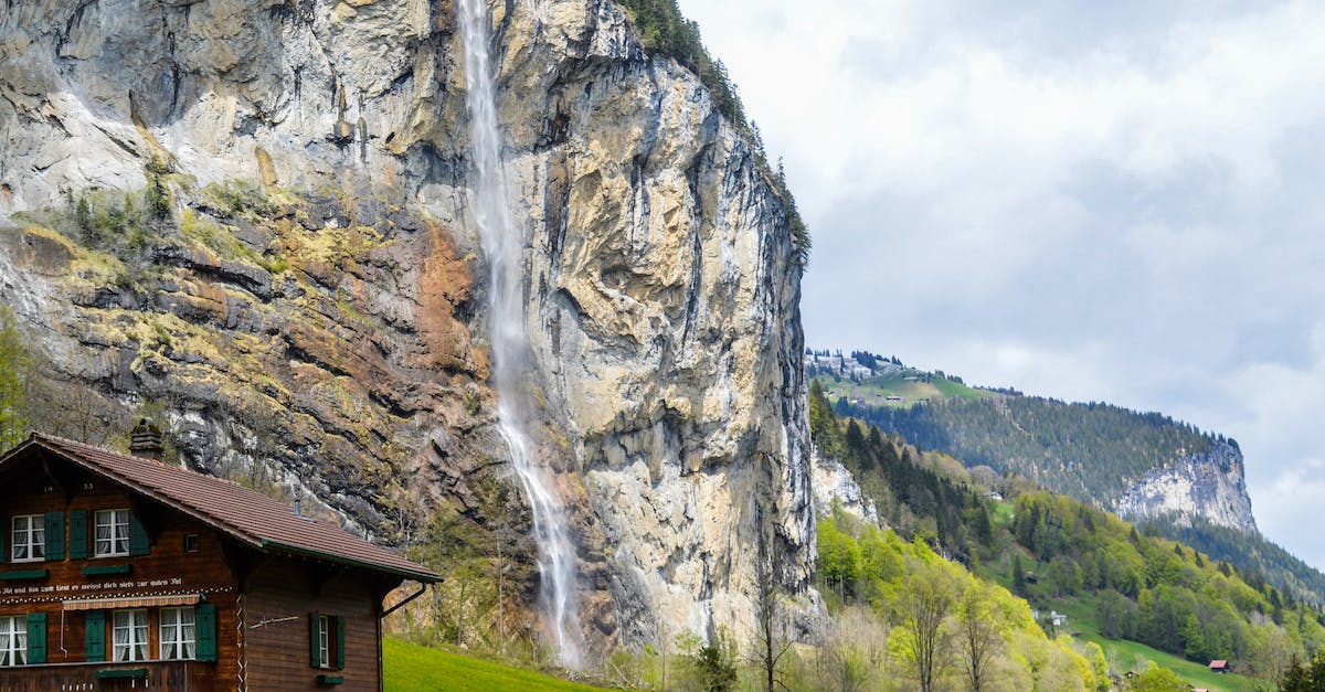 High ping and low FPS when streaming with OBS on Twitch? - Low angle of aged residential house facades near high ridge with rapid cascade under cloudy sky