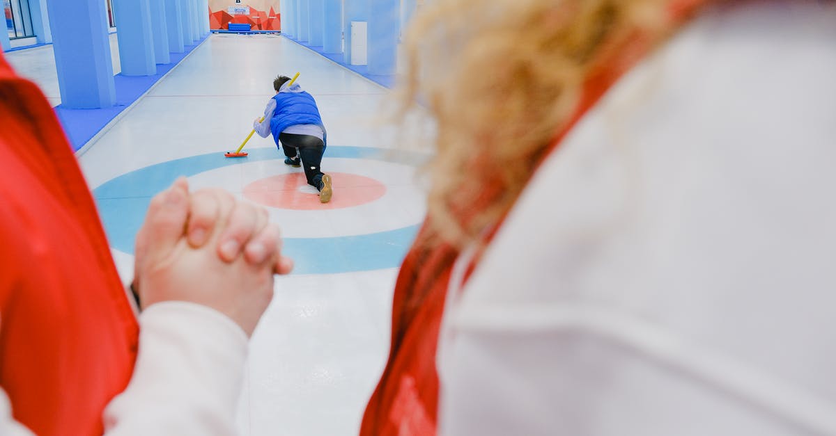 Ho to teleport an an armor stand to a player who just got a kill, then take it away - Sportive team in red vests standing and looking at unrecognizable sportsman in blue vest sliding with stone and broom in hand while playing curling on ice rink
