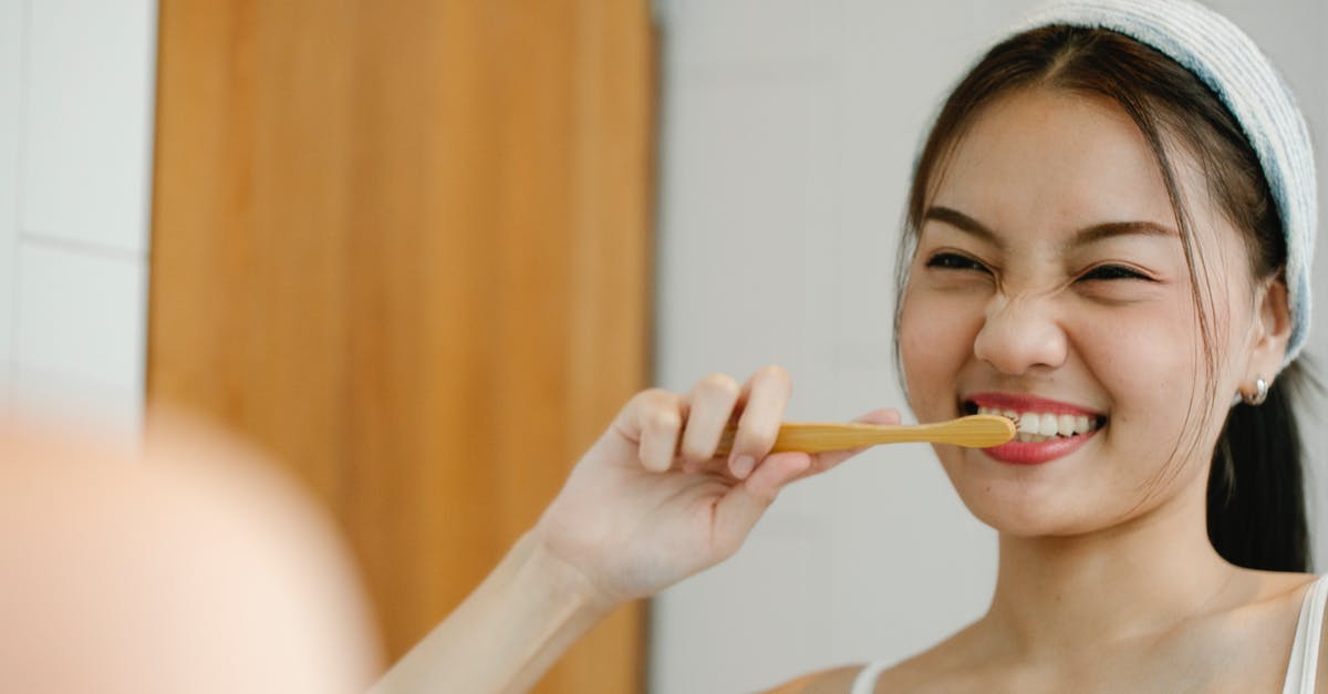 How a Genius Sim can make money at home while having Fun? - Positive Asian woman brushing teeth