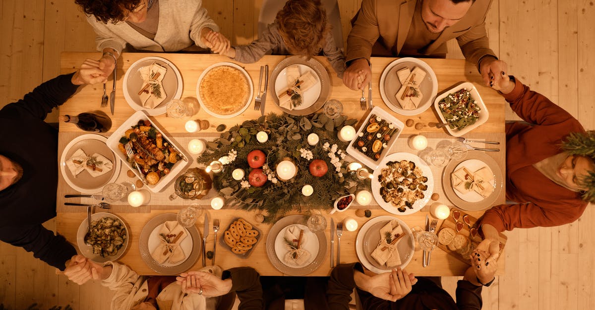 How are Assassin's Creed 1 and 2 related to Assassin's Creed 4? - Top View of a Family Praying Before Christmas Dinner