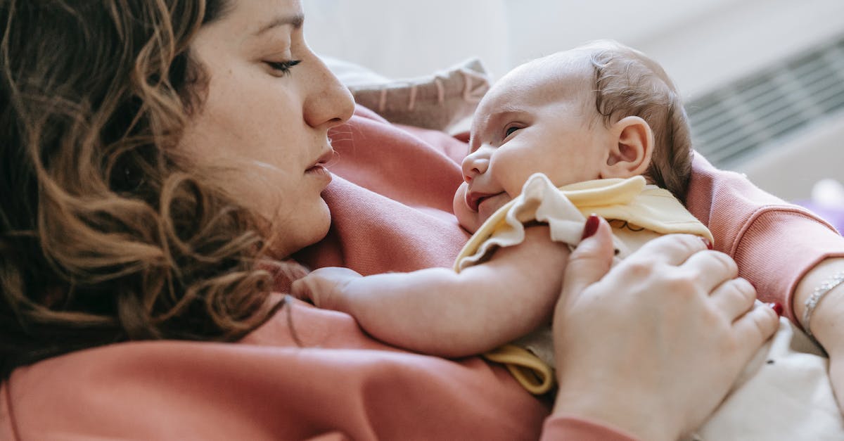 How are Desmond's assassin ancestors related to each other? - Side view of caring mother with cute newborn baby in arms looking at each other while sitting on couch in room How are Desmond's assassin ancestors related to each other? - Side view of caring mother with cute newborn baby in arms looking at each other while sitting on couch in room