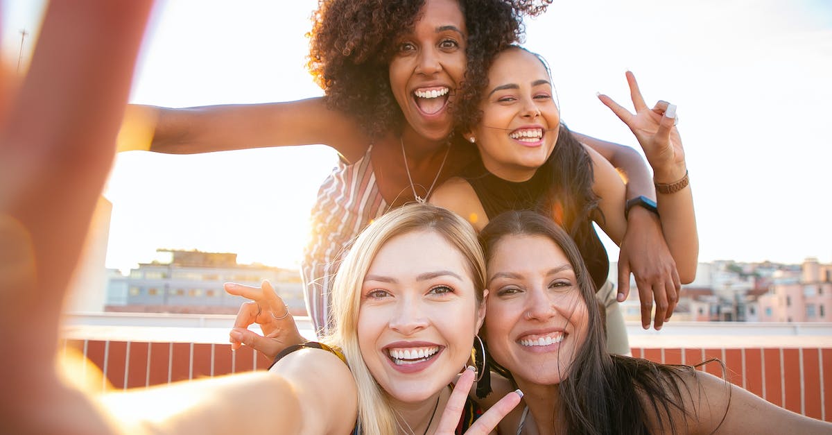 How best to maximise a Thorns-based Crusader build? - Cheerful young diverse women showing V sign while taking selfie on rooftop