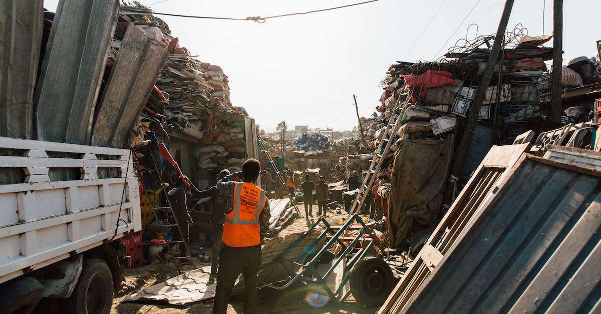 How big is a stack? - Unrecognizable workmen standing near pile of metal scrap in dump How big is a stack? - Unrecognizable workmen standing near pile of metal scrap in dump
