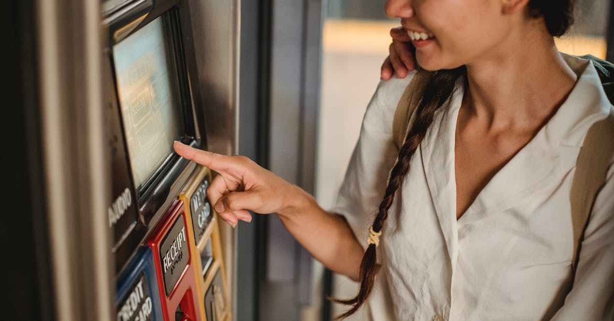 How can I avoid being killed by Subway Stewards/Ticket Inspectors? - Crop smiling Asian female in white shirt using ticket vending machine with touch screen in underground