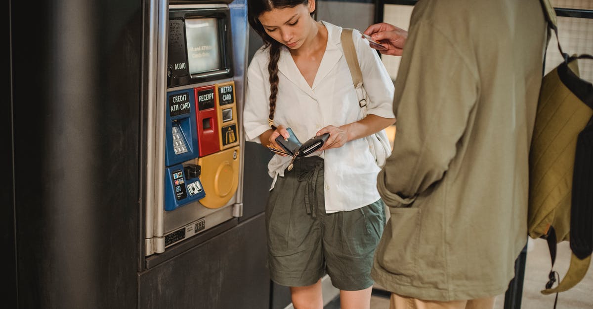 How can I avoid being killed by Subway Stewards/Ticket Inspectors? - Calm young couple wearing casual clothes standing together near ticket vending machine with wallet in hands in underground