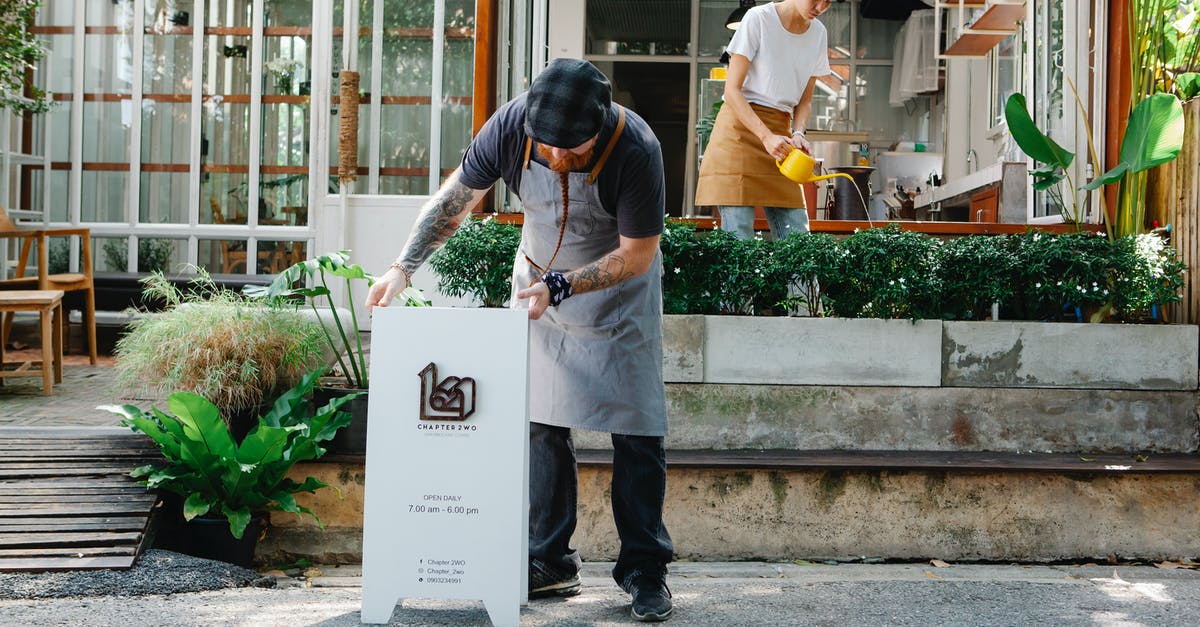 How can I build a 'shop' that trades score for weaponry? - Couple of coworkers in aprons and casual clothes watering plants and putting signboard near cafeteria in daytime How can I build a 'shop' that trades score for weaponry? - Couple of coworkers in aprons and casual clothes watering plants and putting signboard near cafeteria in daytime