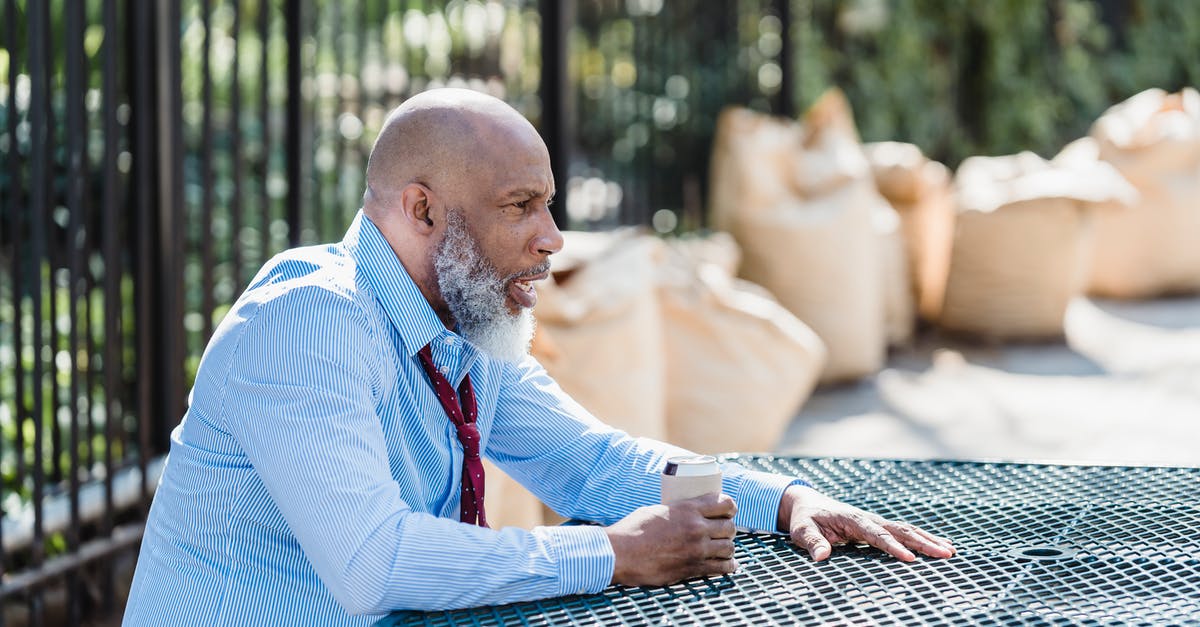 How can I check the age of a city? - Side view of concerned African American male entrepreneur in formal clothes with can of alcohol beverage sitting at table on street How can I check the age of a city? - Side view of concerned African American male entrepreneur in formal clothes with can of alcohol beverage sitting at table on street