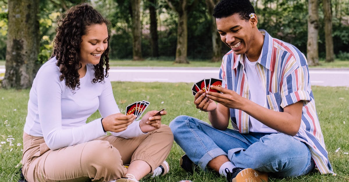 How can I check the first date of a Steam game being played in my library? - Man and Woman Sitting on Grass Playing Cards