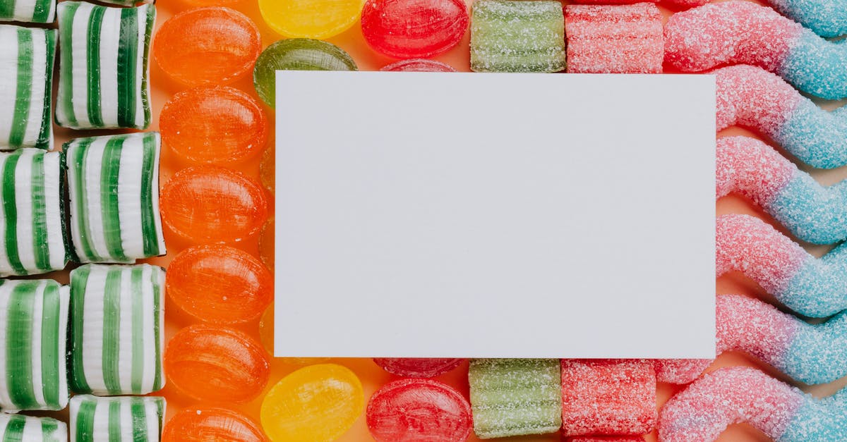 How can I check when a PSN gift card “top-up card” got used? (Or maybe other meta data about its use.) - Top view closeup of blank paper card placed on multicolored various shapes yummy candies in light confectionery