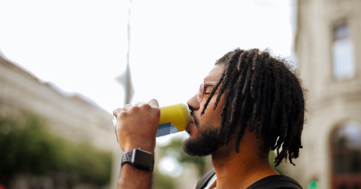 How can I decrease the health of an item by 1? - Side view of adult Hispanic guy with dreadlocks in sunglasses and casual clothes with backpack and smart watch drinking yummy beverage from vivid yellow can while standing with eyes closed on street in downtown