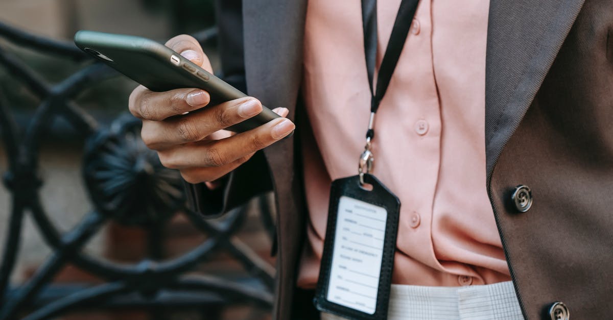 How can I disguise my own name (for my screen) in chat on a recording? - Crop unrecognizable African American female entrepreneur in stylish suit with name tag messaging on mobile phone while standing on city street in daytime