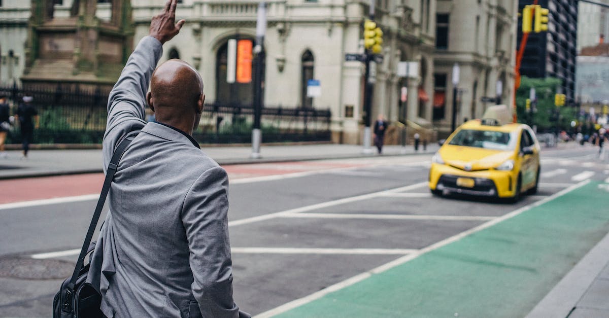 How can I do Taxi missions without waiting? - Back view of anonymous African American male with hand up catching yellow cab on blurred background of road