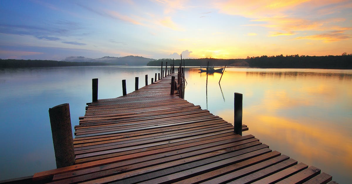 How can I dock a boat without breaking it? - Brown Wooden Dock on Calm Body of Water Surrounded by Silhouette of Trees during Sunset