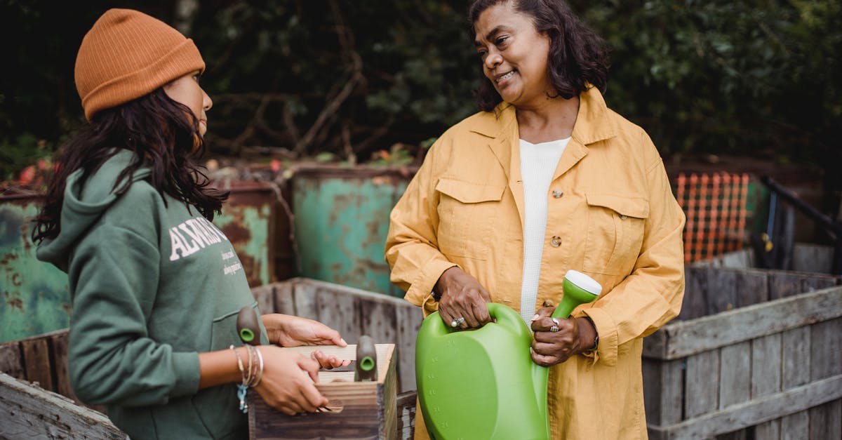 How can I farm for a specific type of heirloom? - Smiling ethnic farmers with gardening instruments speaking in countryside How can I farm for a specific type of heirloom? - Smiling ethnic farmers with gardening instruments speaking in countryside