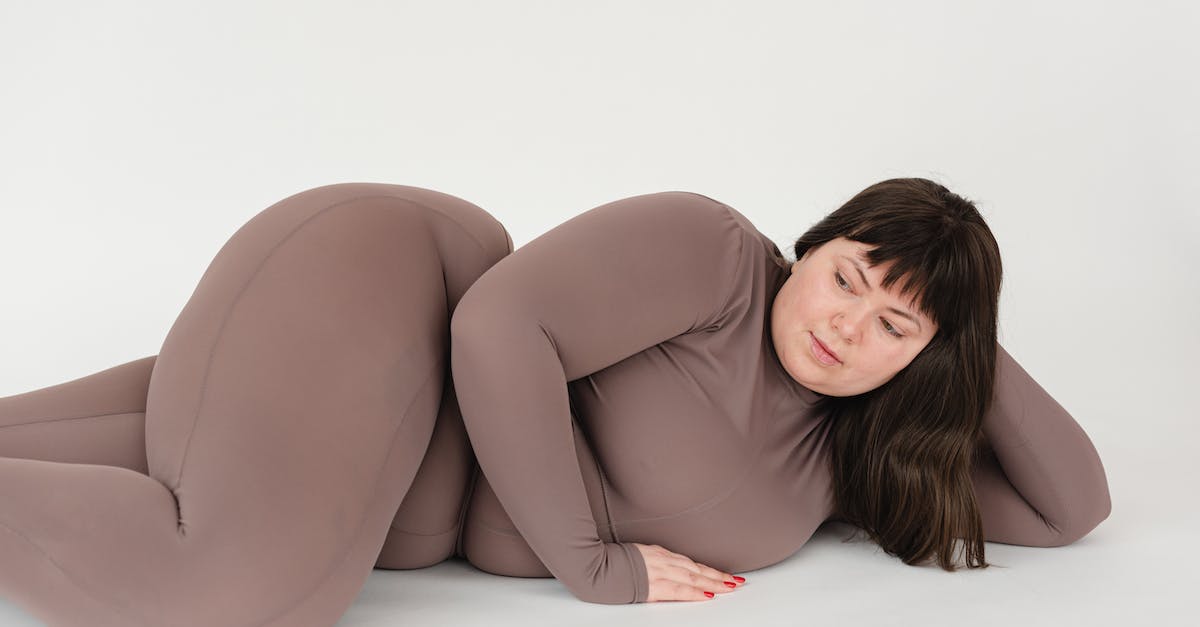 How can I figure out what happened while I was away from the game? - High angle of serious plus size female with long hair leaning on hand while lying against white background