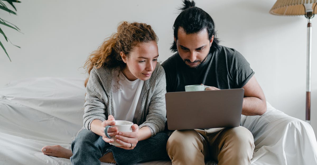 How can I fix "Connection timed out" when connecting to a server after watching youtube or taxing my computer [duplicate] - Positive young couple in casual clothes sitting on sofa with white cover and surfing netbook
