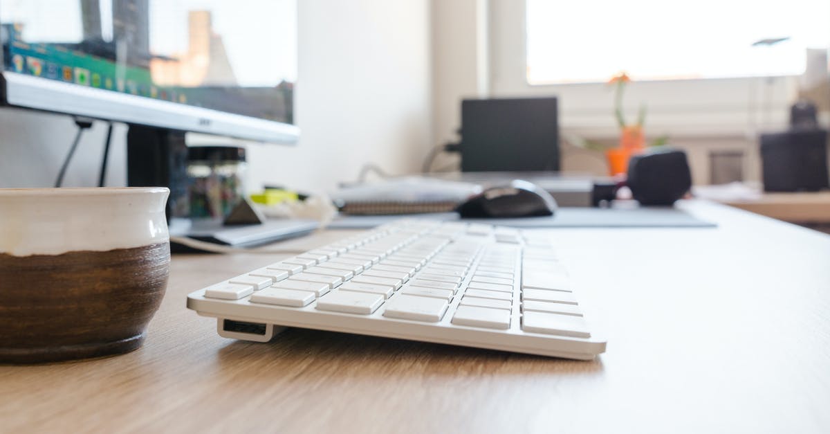 How can I force the mouse cursor to stay in the window of another game, when XCOM / XCOM 2 is running in the background? - Selective Focus Photography of Wireless Keyboard on Desk