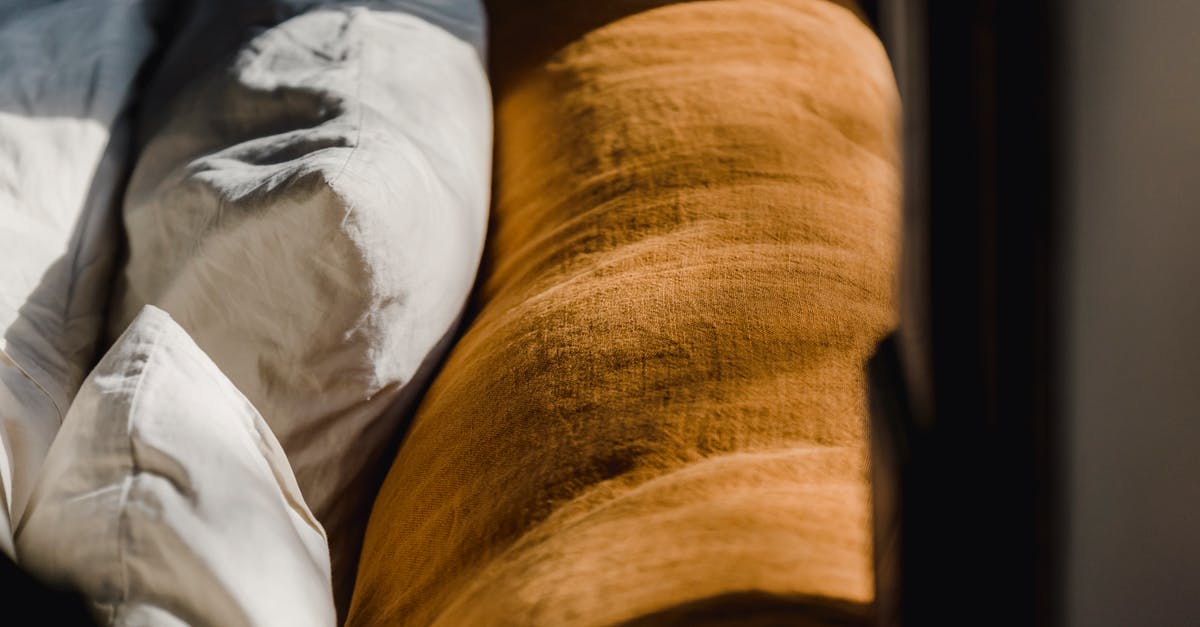 How can I get my furniture back on freeplay sims? - Soft cozy back of brown couch and cushions in white cotton sheets under sunshine from window