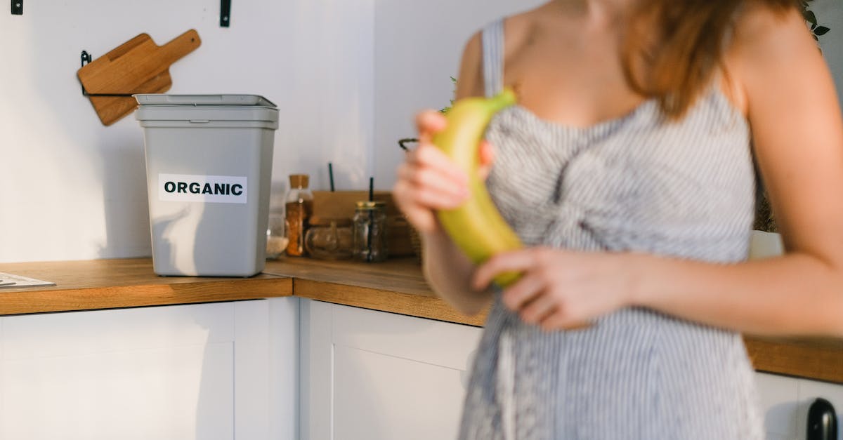 How can I get rid of crops? - Crop woman with organic banana in hands standing in kitchen