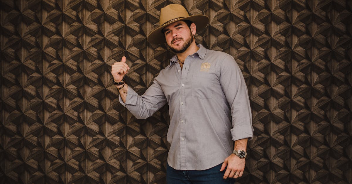How can I get started making money? - Portrait of Smiling Man in Hat Making Hand Gesture