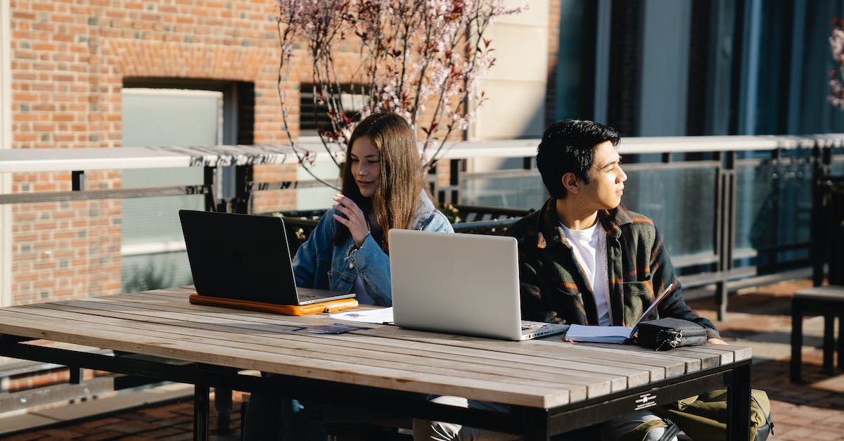 How can I get the computers to stop pestering me? - Man and Woman Sitting at Table Using Laptop How can I get the computers to stop pestering me? - Man and Woman Sitting at Table Using Laptop