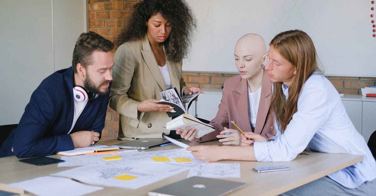 How can I have data be different for three identical blocks? - Group of multiracial businesspeople speaking and sharing data about project and analyzing reports in notebooks at table in office