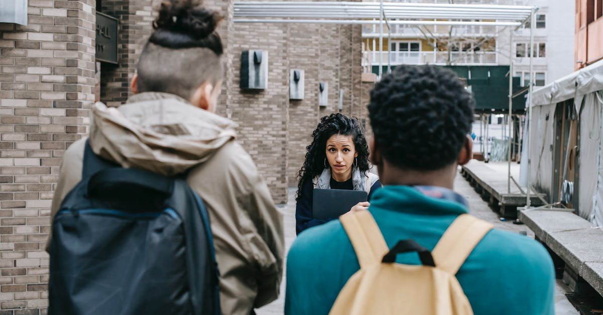 How can I make bullets rotate the other way with the Skimmer? - Back view of faceless multiracial friends with backpacks blocking way for Latin American classmate