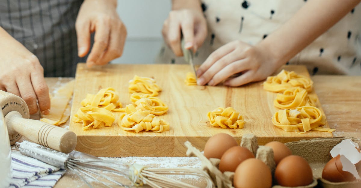 How can I make members of a Team in Minecraft Invulnerable? - Faceless females in aprons at wooden table making homemade pasta cutting dough into strips