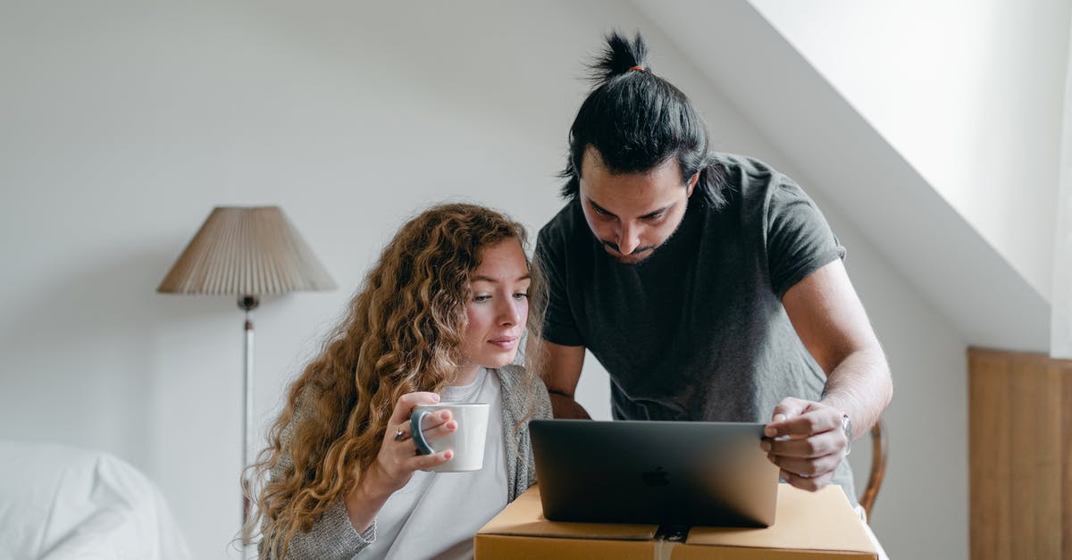 How can I migrate The Sims 3 Expansion Packs and Stuff Packs games from my old laptop to a new computer? - Concentrated young couple in casual outfit browsing netbook and packing stuff into carton boxes and suitcases to move out