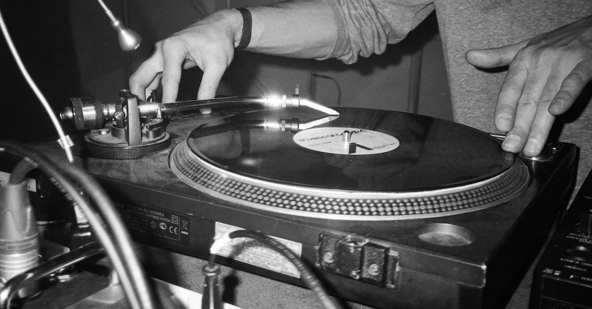 How can I open or play Aladdin's soundtrack (JAM audio format)? - Grayscale Photography of Person Playing Turntable