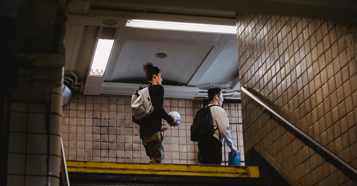 How can I pass through low height tunnels? - Young men walking on metro staircase How can I pass through low height tunnels? - Young men walking on metro staircase