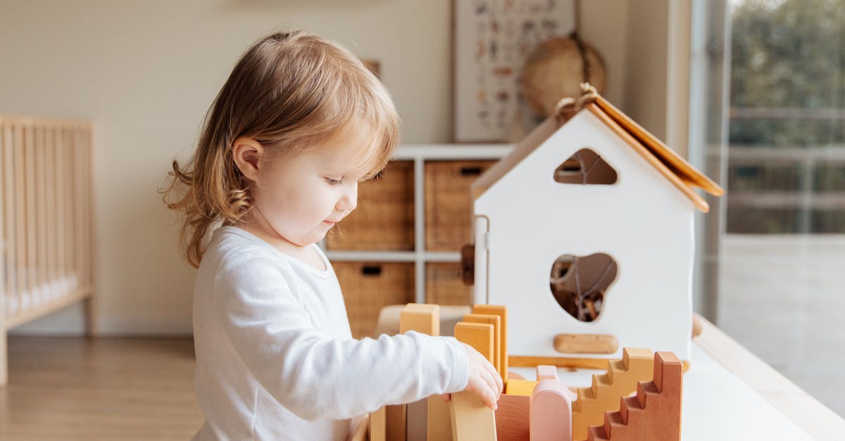 How can I play a message if a command block isn't activated? - Cute little girl playing with wooden blocks at table near window at home