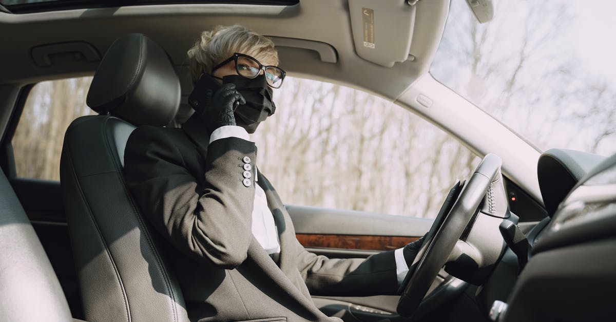 How can I prevent my hero from auto-attacking? - From below side view of unrecognizable woman in formal clothes and protective mask and gloves talking on cellphone while driving contemporary car