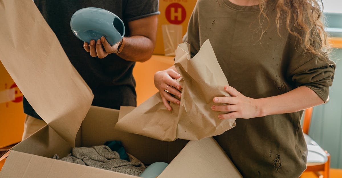 How can I receive a new verification email? - Crop faceless young woman and man unpacking belongings after moving in new house