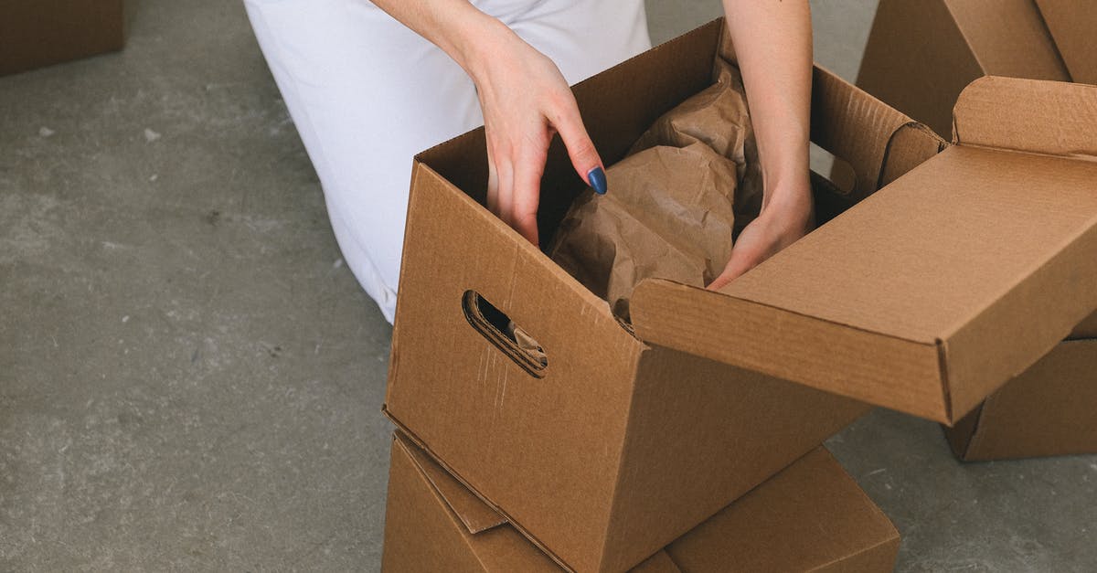 How can I receive a new verification email? - Crop faceless woman packing belongings into cardboard box before relocation