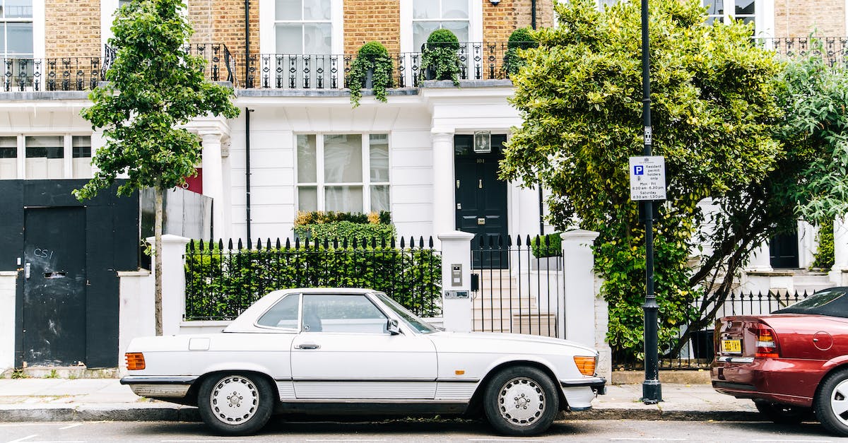 How can I reliably find a police car? - White Coupe Near Brown and White Concrete Building