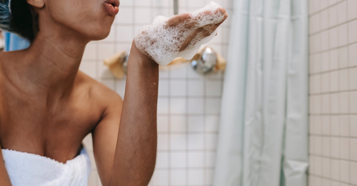 How can i remove infinite water sources? [duplicate] - Side view of crop anonymous African American female in towel blowing off foam from hand in bathroom