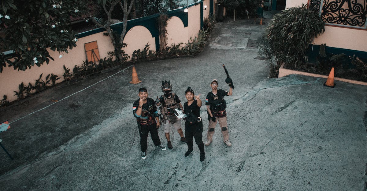 How can I rotate the camera around my character with my weapon out? - Behind scene of film making with Asian men having fun on street