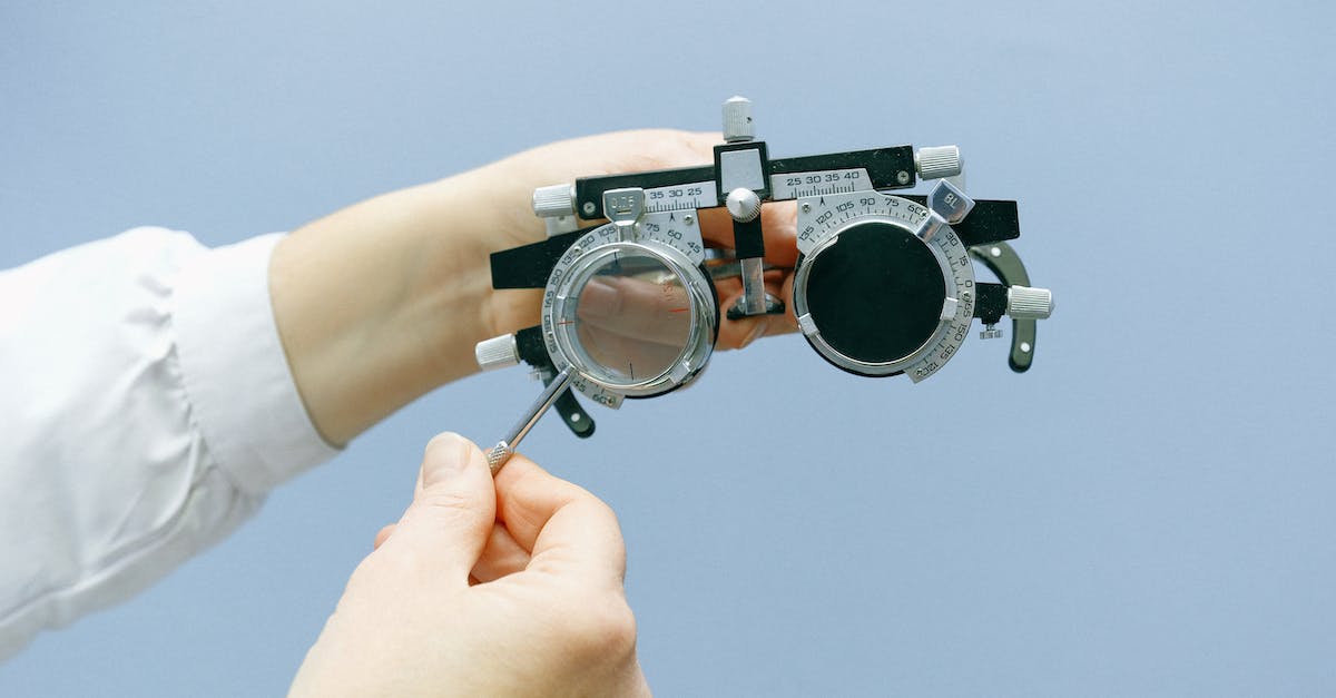 How can I satisfy a part testing contract? - Crop unrecognizable doctor with vision test device