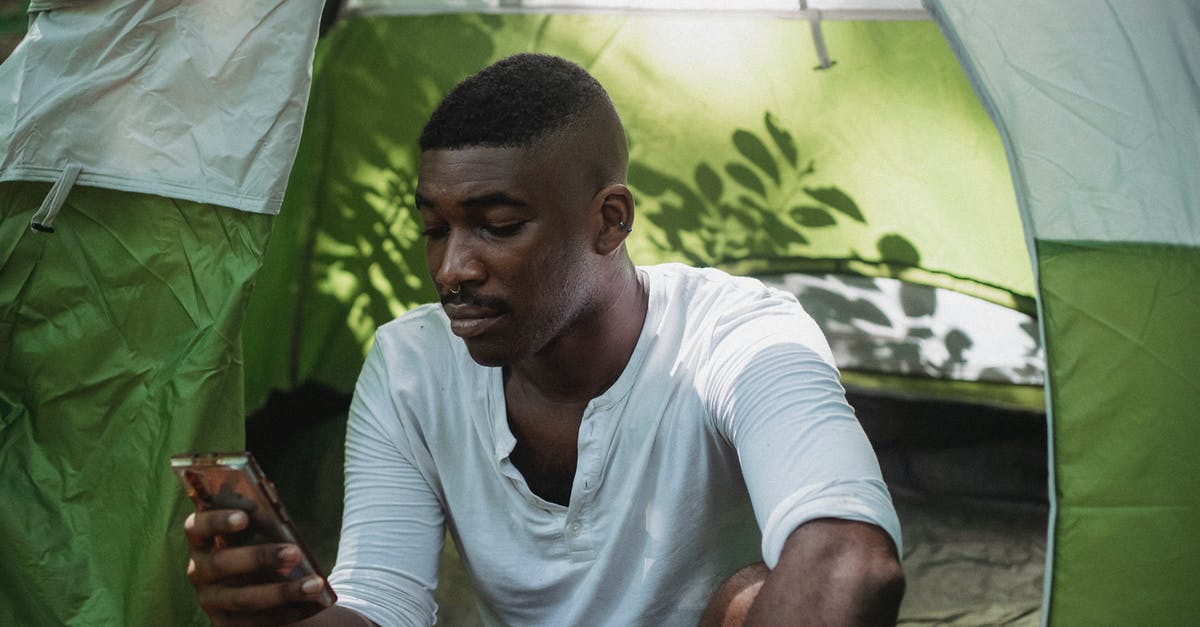 How can I scroll down to read the full item descriptions? - Serious black man using smartphone in tent