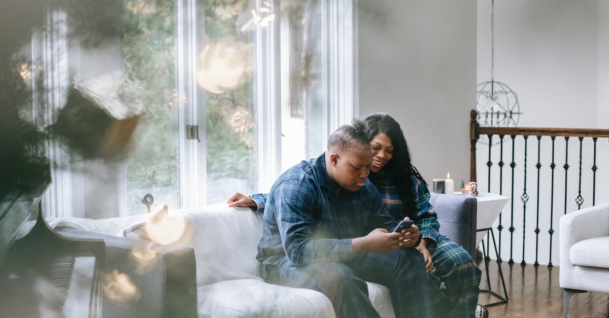 How can I scroll down to read the full item descriptions? - Focused black teen son watching smartphone while sitting with mother How can I scroll down to read the full item descriptions? - Focused black teen son watching smartphone while sitting with mother
