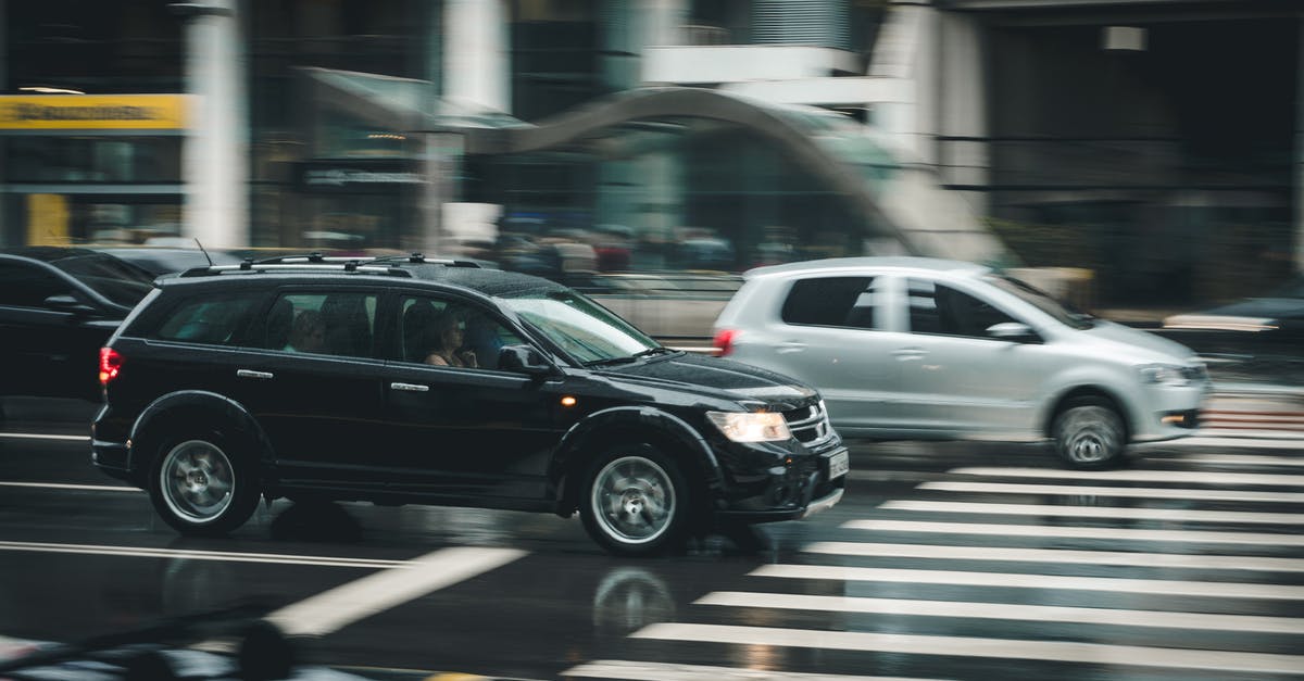 How can I stop moving vehicles without having to chase it down? - Black Suv Beside Grey Auv Crossing the Pedestrian Line during Daytime