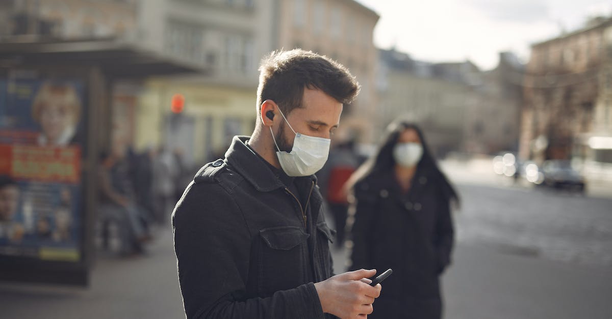 How can I stop without destroying the minecart nor using redstone? - Focused man in medical mask using smartphone on urban street in cold season