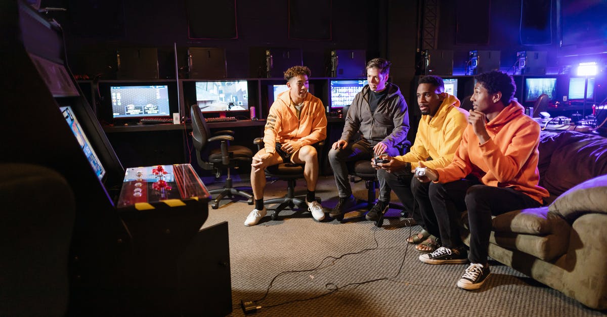 How can I tell which DLC my friends have for their games? - Friends Having Fun Playing an Arcade Video Game