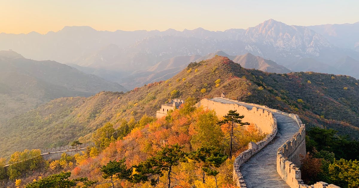 How can I unlock the great adventure achievement? - Picturesque landscape of Great Wall of China on hill with green trees and mountains on background on sunny day