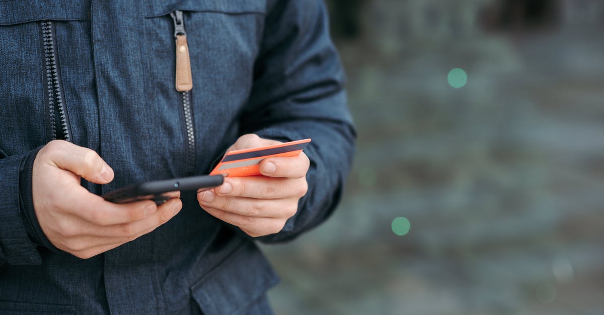 How can I use Card Order? - Man holding credit card and browsing smartphone on street How can I use Card Order? - Man holding credit card and browsing smartphone on street