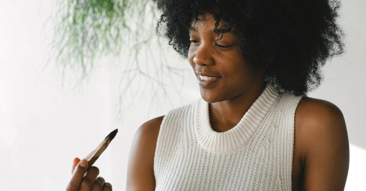 How can I view the content of a USB stick on a PS4? - Satisfied African American female with wooden palo santo stick enjoying aromatherapy at home