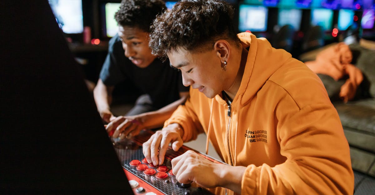 How can modern Arcade machines have thousands of games while the originals could only hold one? - Two Men Playing an Arcade Video Game How can modern Arcade machines have thousands of games while the originals could only hold one? - Two Men Playing an Arcade Video Game