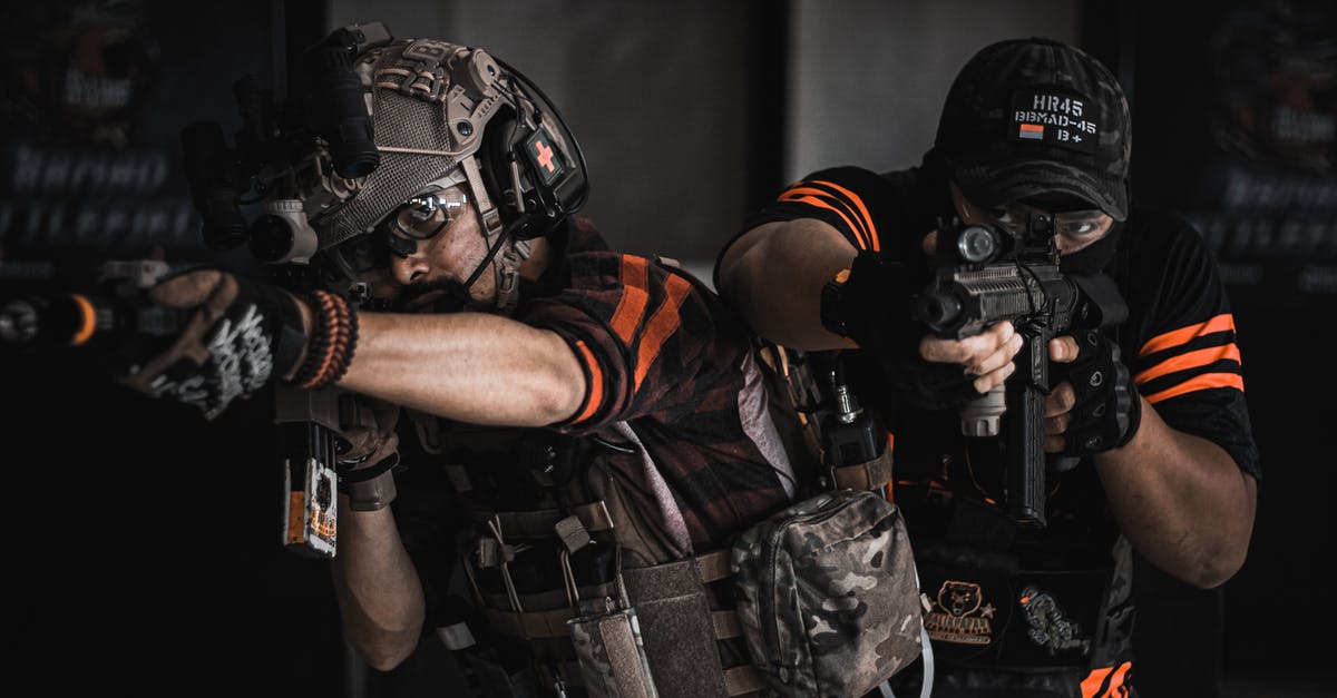 How can we force the military to kill civilians? - Two Man Pointing Gun Wearing Black And Orange How can we force the military to kill civilians? - Two Man Pointing Gun Wearing Black And Orange