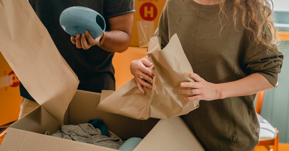 How close can villagers move to your house? - Crop faceless young woman and man unpacking belongings after moving in new house